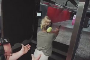 Une femme essaye un gros calibre dans un stand de tirs